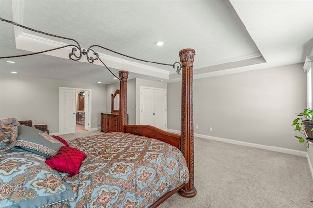 bedroom with ornamental molding, a raised ceiling, light colored carpet, and baseboards