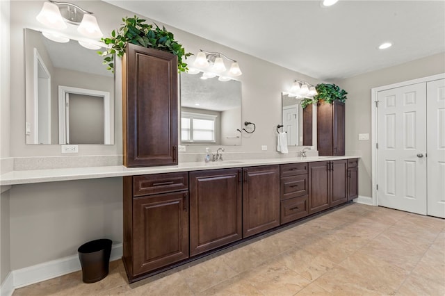 full bathroom with double vanity, recessed lighting, a sink, and baseboards