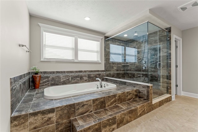 full bathroom with visible vents, a garden tub, a textured ceiling, and a shower stall