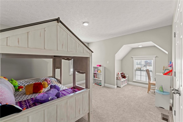 bedroom featuring light colored carpet, visible vents, vaulted ceiling, a textured ceiling, and baseboards