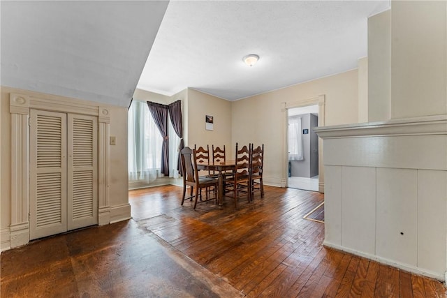 dining room featuring dark wood-style flooring and baseboards