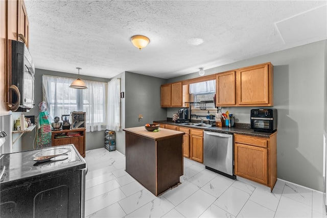 kitchen with dark countertops, black appliances, a kitchen island, and brown cabinets