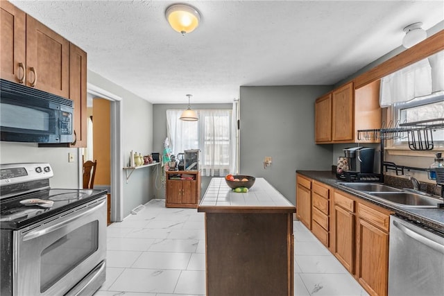 kitchen featuring brown cabinetry, a center island, marble finish floor, stainless steel appliances, and a sink