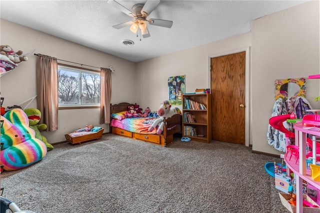 bedroom featuring a textured ceiling, carpet, visible vents, and a ceiling fan