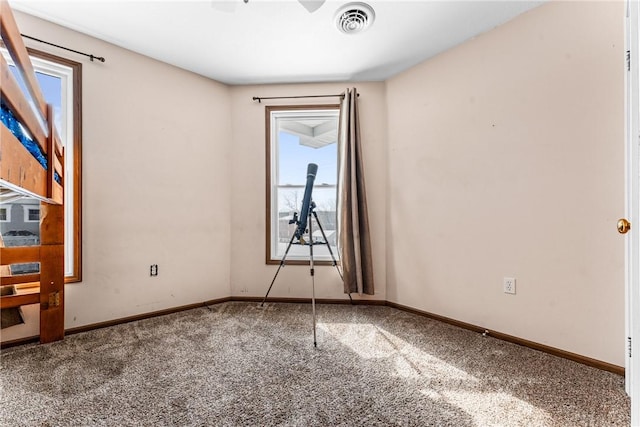 carpeted spare room featuring visible vents and baseboards