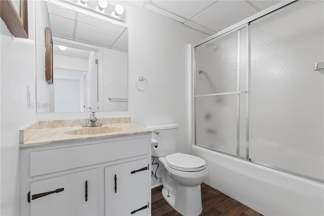 full bathroom with toilet, enclosed tub / shower combo, wood finished floors, vanity, and a paneled ceiling