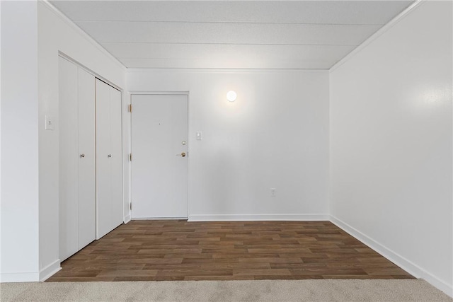 spare room with baseboards and dark wood-style flooring