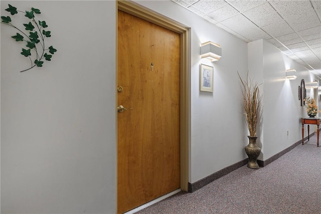 hallway featuring carpet flooring and baseboards