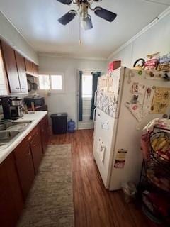 kitchen with ceiling fan, light countertops, freestanding refrigerator, dark wood-style floors, and crown molding