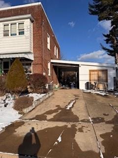 view of property exterior with brick siding and driveway