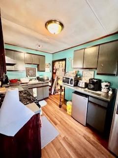 kitchen featuring stainless steel appliances, light wood finished floors, and light countertops