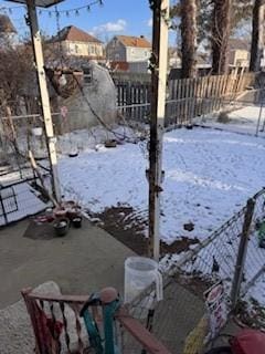 yard covered in snow featuring fence