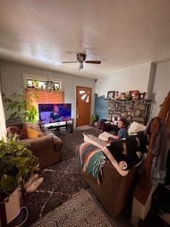 living area featuring a fireplace and a ceiling fan