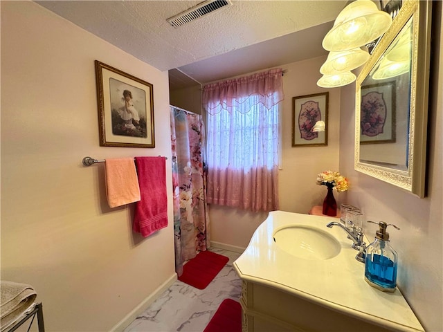 bathroom with baseboards, visible vents, marble finish floor, a textured ceiling, and vanity