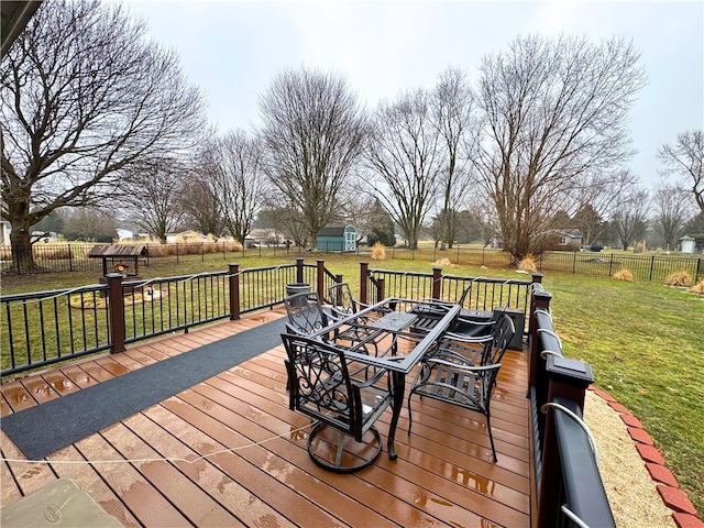 wooden terrace with a fenced backyard, a lawn, an outdoor structure, and a storage shed