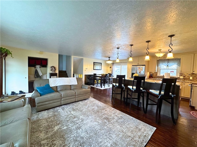 living area featuring a textured ceiling and dark wood-type flooring