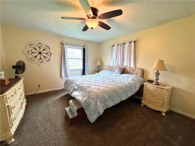 bedroom with a textured ceiling, dark colored carpet, a ceiling fan, and baseboards