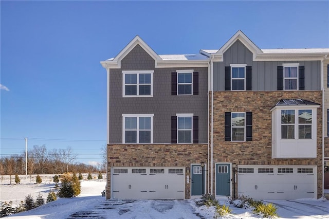 multi unit property featuring board and batten siding, stone siding, and a garage