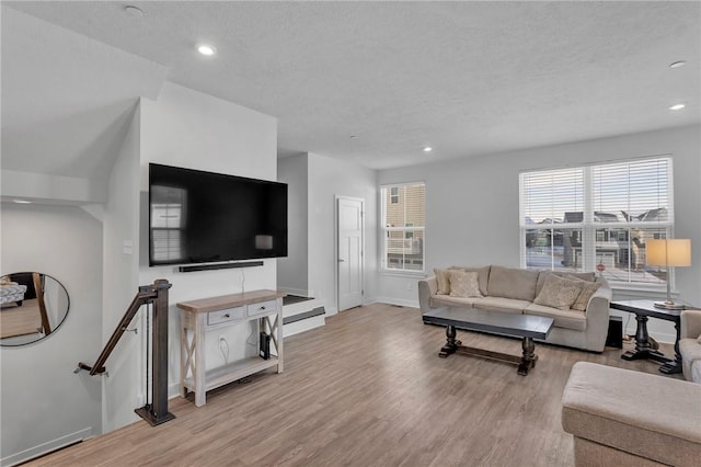 living room with light wood-style floors, recessed lighting, and a textured ceiling