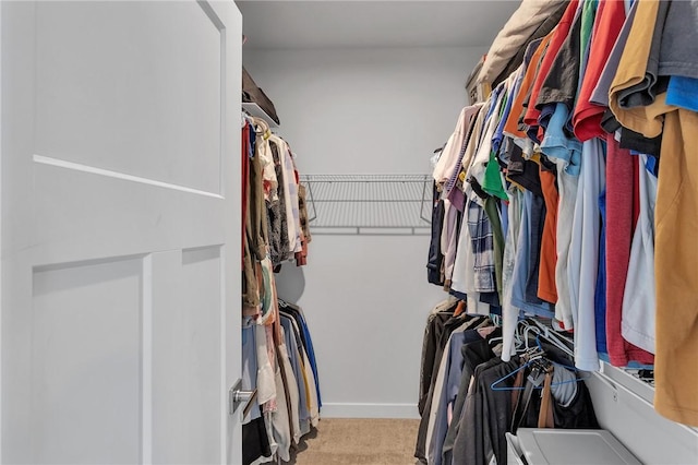 walk in closet with light colored carpet