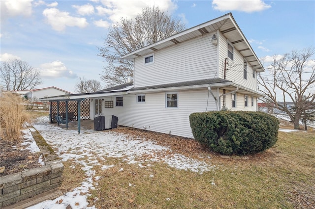 snow covered rear of property with a lawn