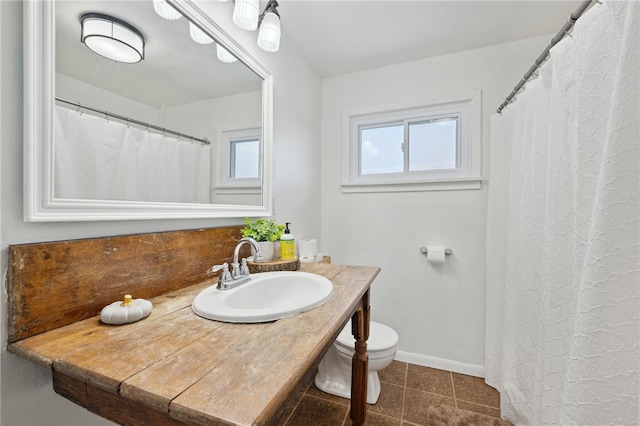 bathroom with toilet, tile patterned flooring, baseboards, and vanity