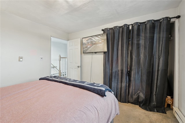 carpeted bedroom featuring a baseboard heating unit