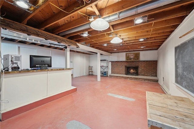 finished basement featuring a brick fireplace and baseboard heating