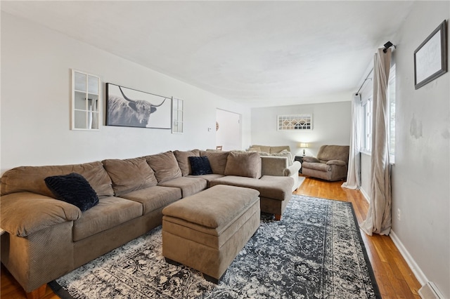 living room with wood finished floors, visible vents, and baseboards