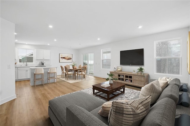 living room featuring baseboards, light wood finished floors, and recessed lighting