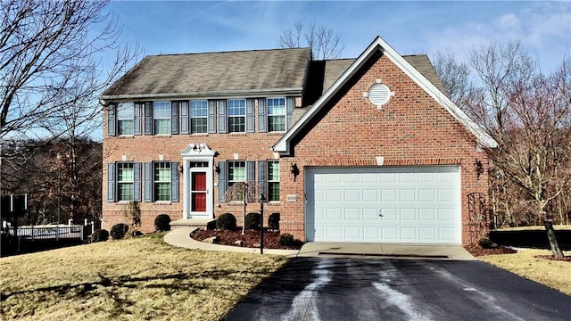 view of front of home with a garage, brick siding, driveway, and a front lawn