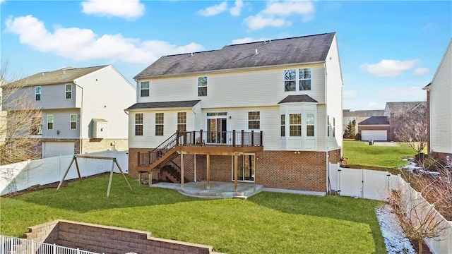 rear view of house with a fenced backyard, a lawn, stairway, a wooden deck, and a gate