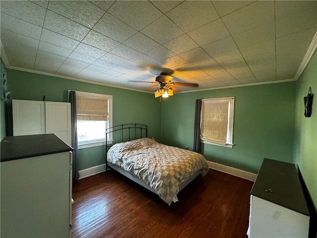 bedroom with dark wood-style flooring, crown molding, baseboards, and ceiling fan