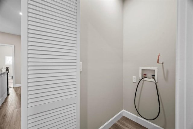 clothes washing area featuring washer hookup, laundry area, baseboards, and wood finished floors