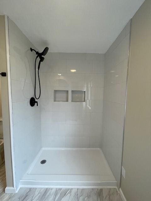 full bathroom featuring a stall shower and marble finish floor