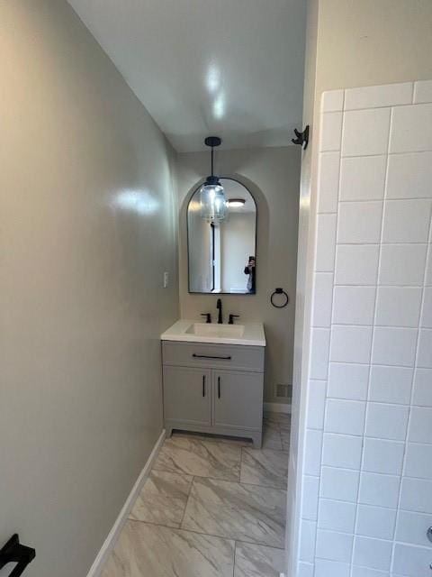 bathroom featuring marble finish floor, vanity, and baseboards