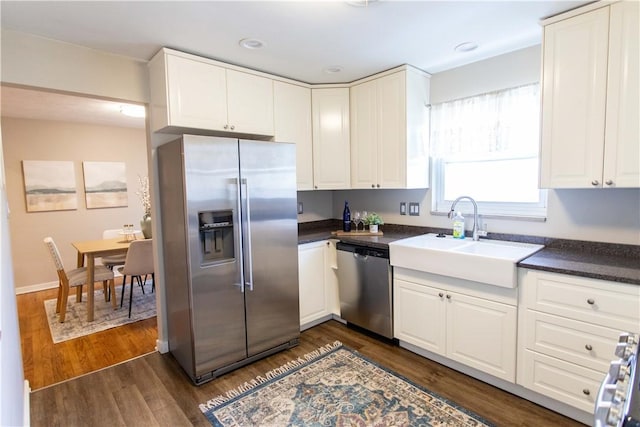 kitchen featuring appliances with stainless steel finishes, white cabinets, and a sink