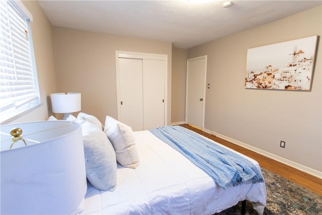 bedroom featuring a closet, baseboards, and wood finished floors