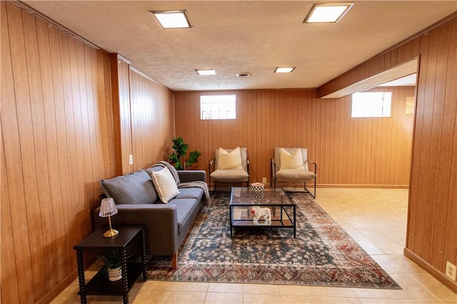 sitting room with a healthy amount of sunlight, wood walls, and light tile patterned floors