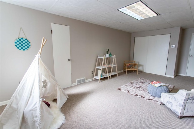 playroom featuring carpet floors, baseboards, visible vents, and a drop ceiling