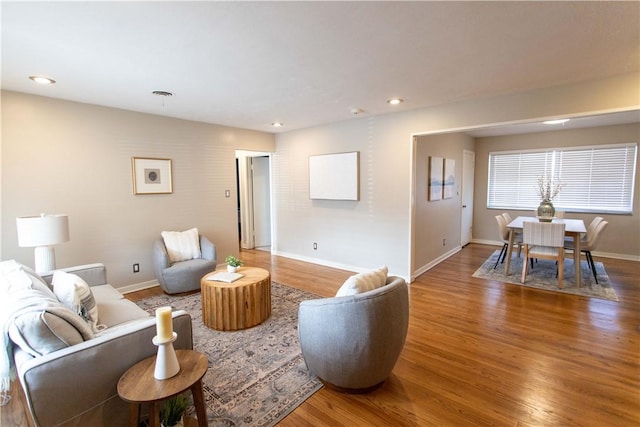 living room with baseboards, wood finished floors, and recessed lighting