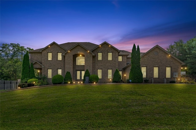 view of front facade featuring a front lawn, fence, and brick siding