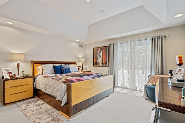 bedroom featuring light carpet, visible vents, a tray ceiling, and recessed lighting