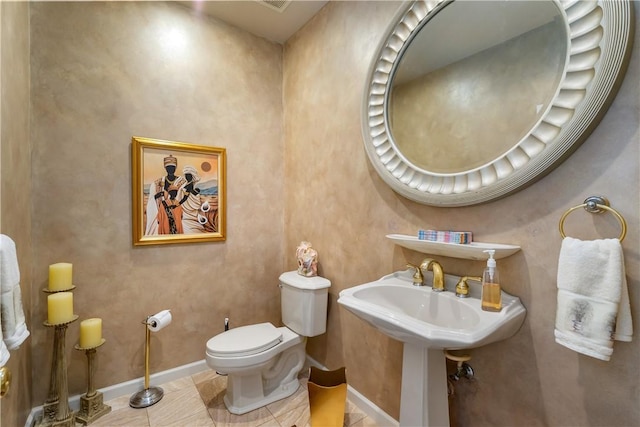 bathroom with baseboards, toilet, and tile patterned floors