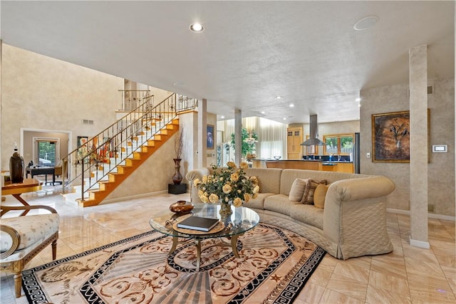 living area with plenty of natural light, stairs, baseboards, and recessed lighting