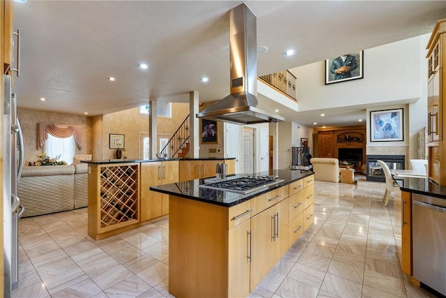 kitchen with island range hood, stainless steel appliances, a fireplace, open floor plan, and a center island