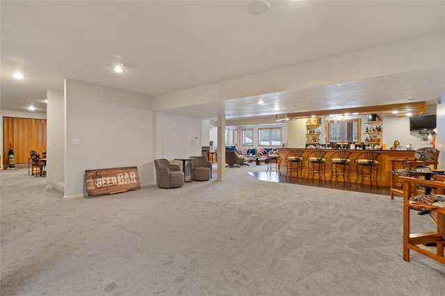 living room with carpet floors, bar, baseboards, and recessed lighting