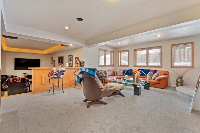 living area with recessed lighting, a raised ceiling, and light colored carpet