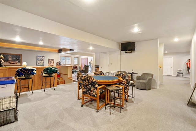dining room with a bar, recessed lighting, and light colored carpet