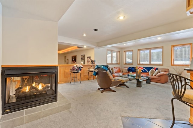 living area featuring recessed lighting, a multi sided fireplace, and light colored carpet